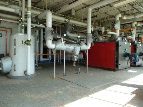 Commercial plant room with red boilers and steel pipework